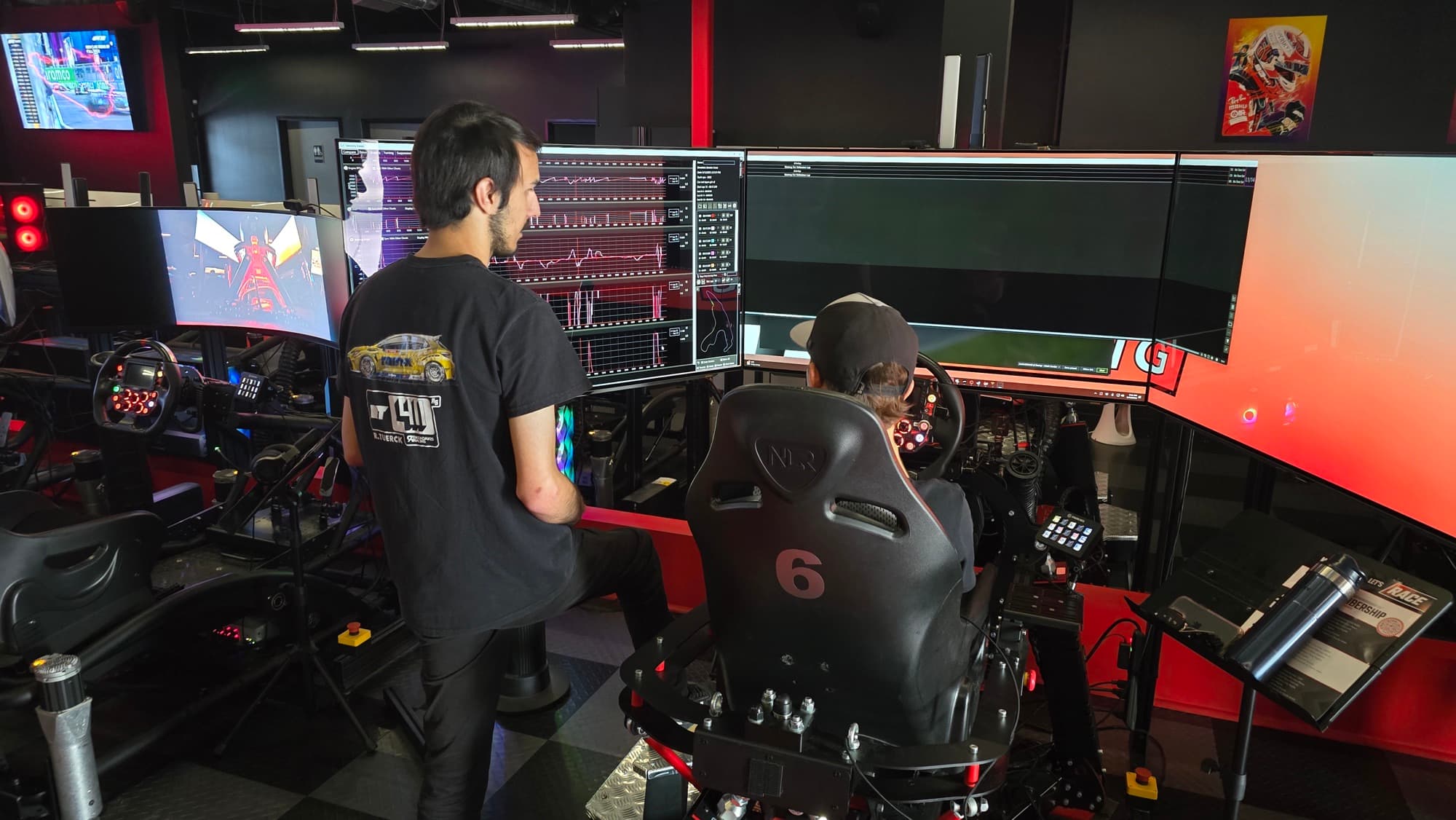 A WOR coach reviewing telemetry with a driver on a simulator