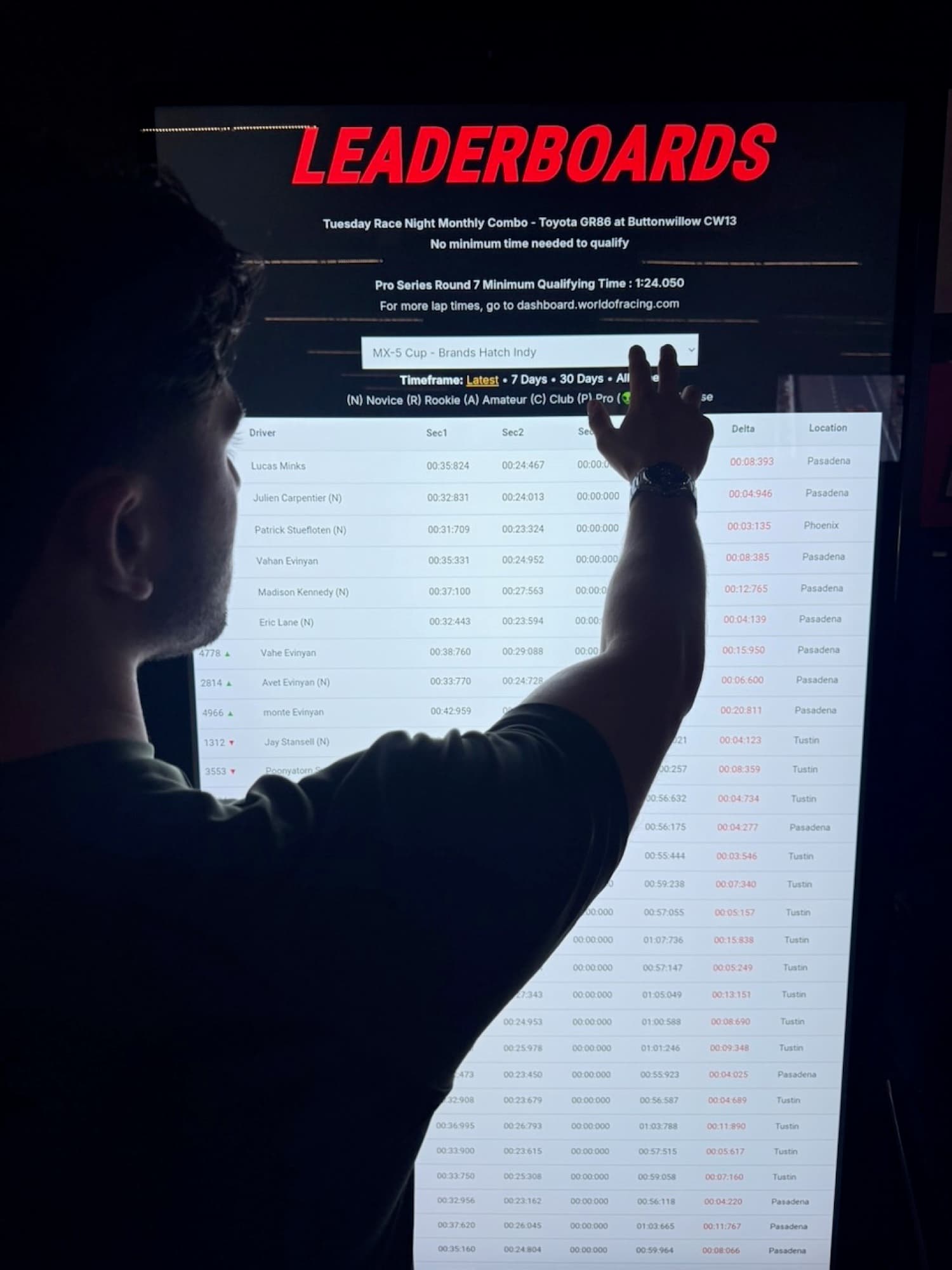 A driver checking lap times on the World of Racing leaderboards screen
