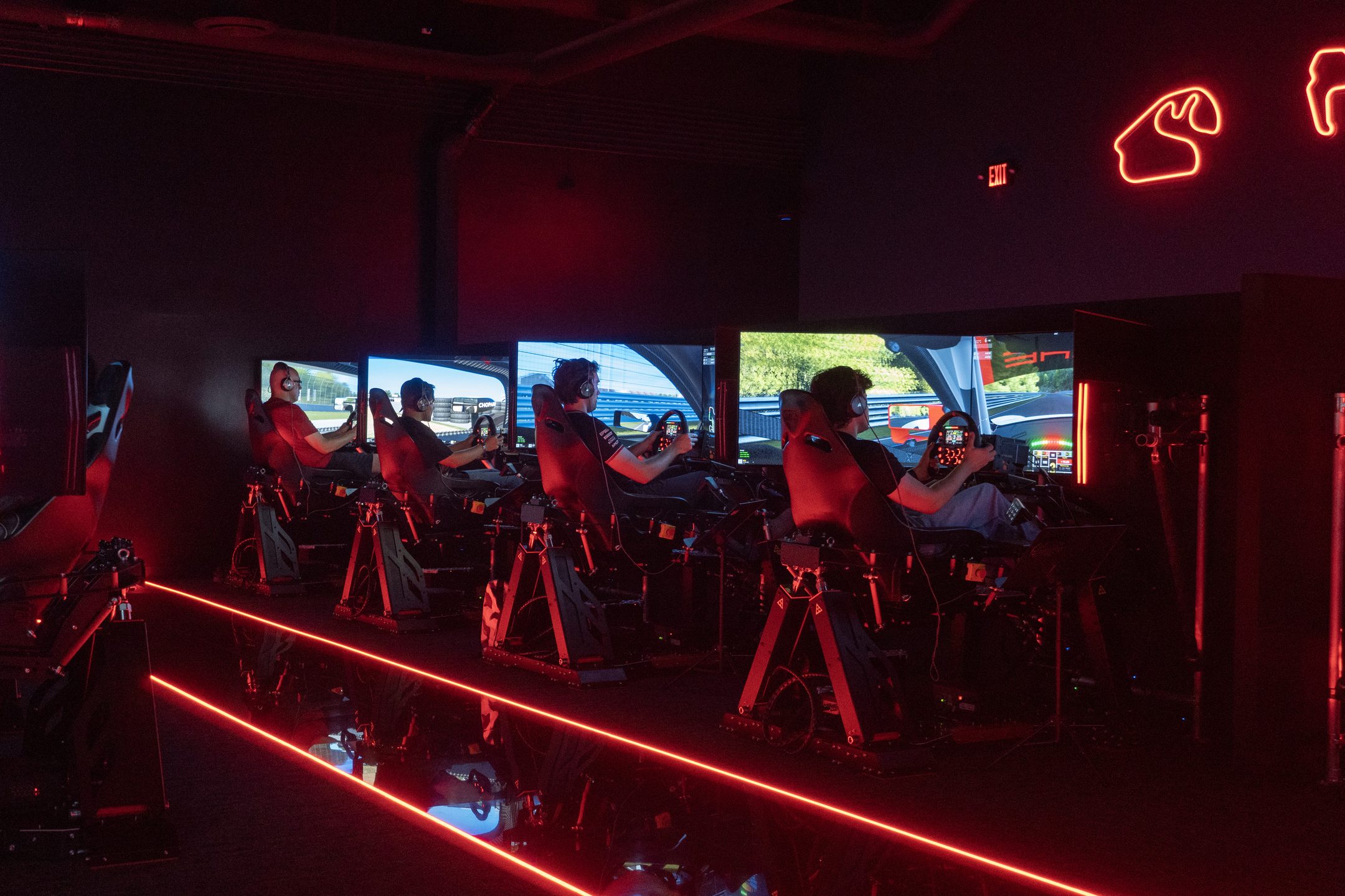 Row of racers mid-session at WOR Tustin under the neon-track ceiling
