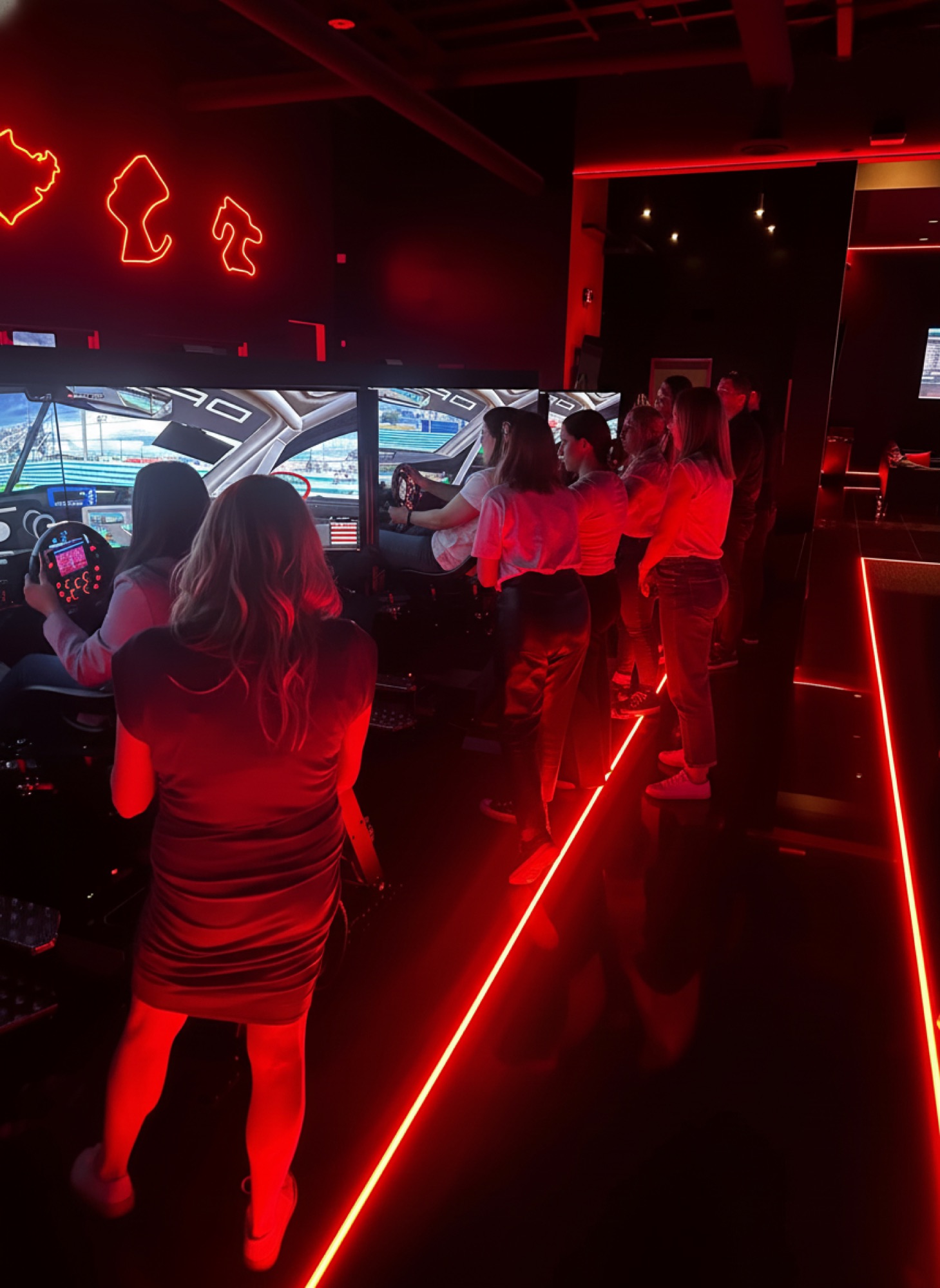 Eight friends lined up at WOR Tustin sim rigs, mid-race