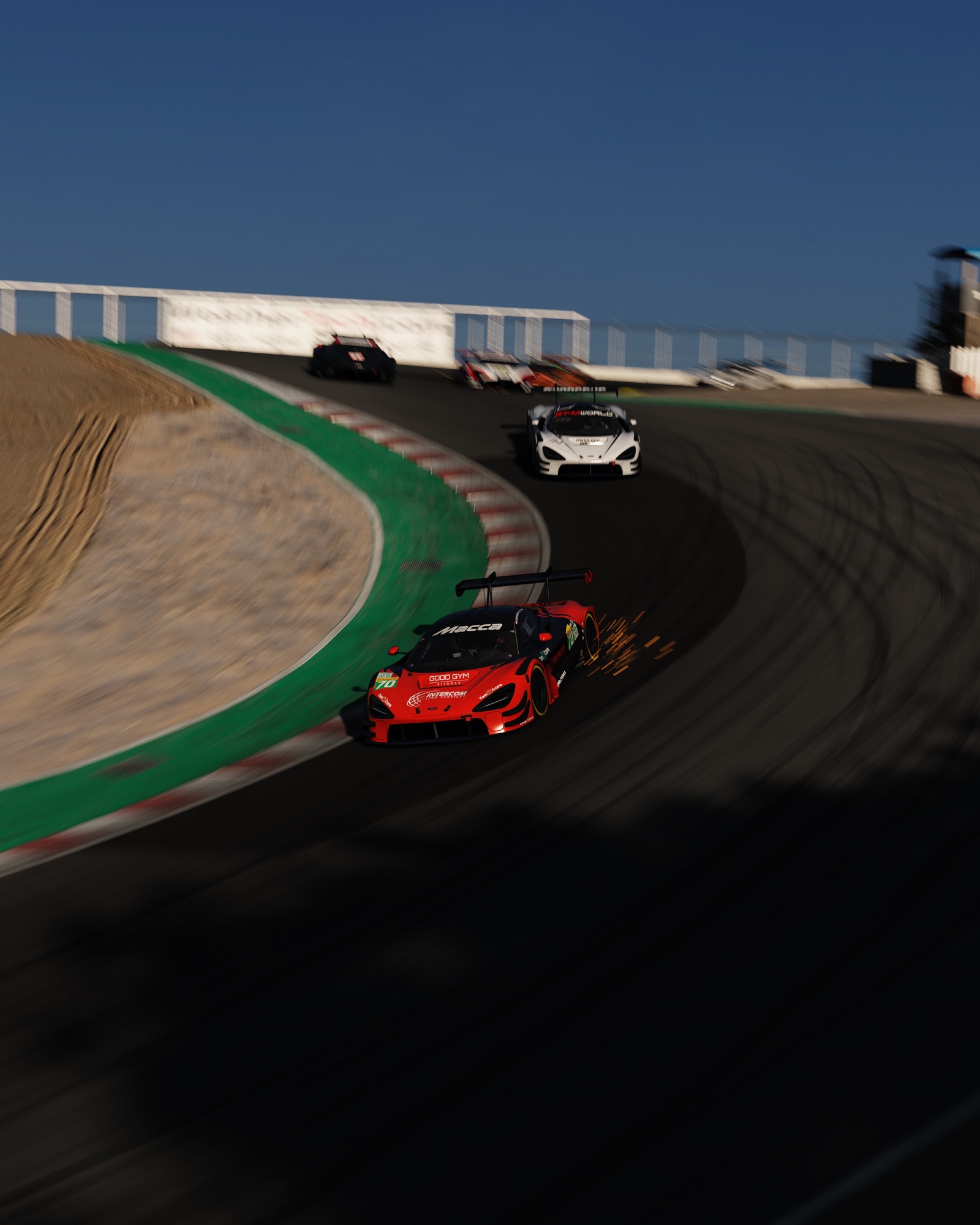 Red McLaren 720S GT3 trailing sparks out of the Corkscrew at Laguna Seca