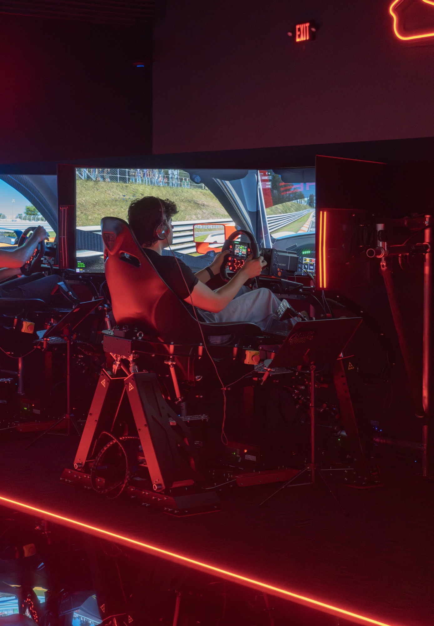 Single driver at a WOR Tustin rig under the ceiling-mounted neon-red track silhouettes